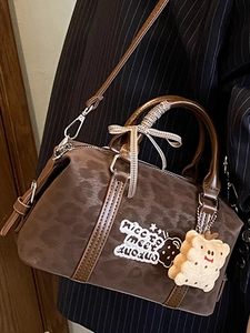 Retro leopard print Boston handbag with cute charm and bow on striped blazer background