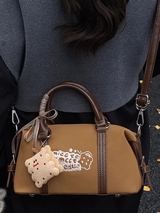 Retro brown Boston bag for women featuring white embroidery and a cute biscuit plush charm