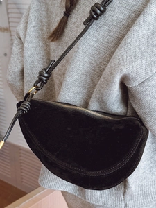 Minimalist black suede crescent crossbody bag with stylish knotted shoulder strap detail