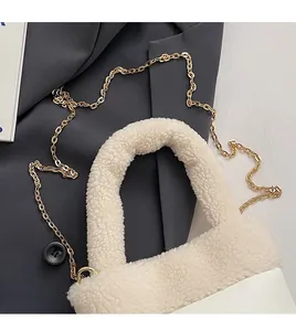 Vue détaillée du sac en fausse fourrure crème avec bandoulière en chaîne dorée chic