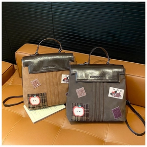 Detail of vintage dual-use backpack featuring mixed textures and cute cartoon patches