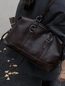 Retro dark brown large tote bag with silver metal ring buckle worn by model outdoors