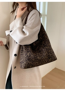 Détail d'un sac cabas léopard porté avec un manteau beige pour un style rétro chic