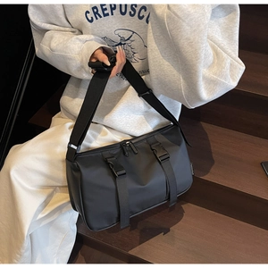 Detail of black sporty crossbody bag with nylon fabric and buckle strap adjustment