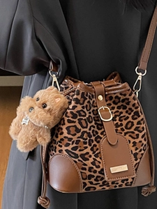 Fashionable leopard print bucket bag with brown leather trim and plush doll charm