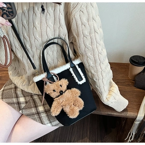 Dettaglio borsa nera con finiture in ecopelliccia bianca e ciondolo orsetto plush