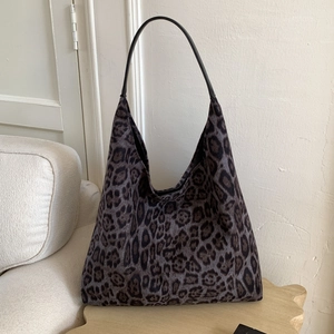 Détail du grand sac cabas imprimé léopard en tissu peluche avec lanières en cuir noir