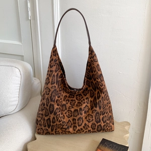 Gros plan du sac hobo léopard avec bandoulière en cuir marron sur une table en bois