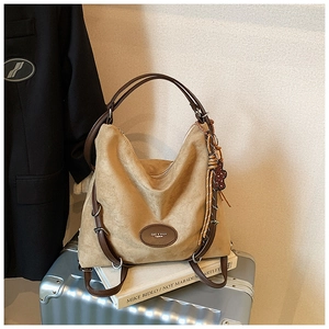 Macro detail of khaki suede hobo bag with deep brown leather straps and metal logo