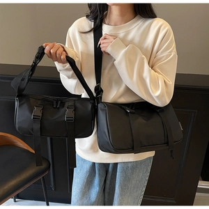 Size comparison of two black nylon crossbody bags showing straps and buckle details