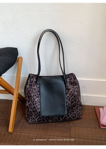 Close-up of leopard print tote bag with purple accents and black leather patchwork