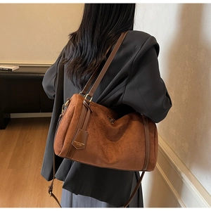 Rear view of a model wearing the brown suede Boston bag with leather shoulder straps