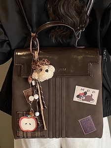 Retro dark brown backpack with fashion patches and a cute plush bear charm for travel