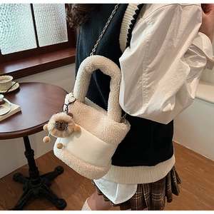 Détail du sac seau beige en fausse fourrure avec patchwork en cuir et breloque peluche
