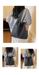 Detail of grey checkered canvas tote with drawstring closure and plush bear charm