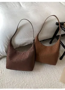 Close-up of leopard print tote bags in dark coffee and caramel suede finishes