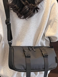 Black waterproof nylon gym bag with adjustable strap and buckle detail in crossbody style