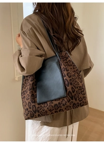 Detail of large leopard print tote bag with black leather pocket and shoulder strap