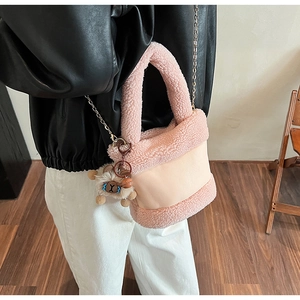 Détail du sac seau rose en peluche avec chaîne dorée et breloque ours adorable