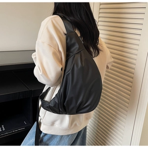Detail of large black nylon crossbody bag showing the sleek waterproof fabric and fit