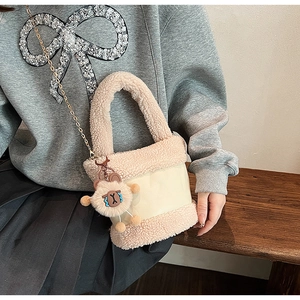 Détail du sac seau beige en peluche avec texture peau d'agneau et chaîne en métal doré
