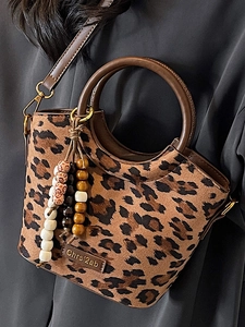 Fashionable leopard print bucket bag with round handles and bohemian beaded tassel detail