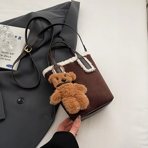 Dettaglio borsa a secchiello in scamosciato con pelliccia e ciondolo a forma di orso