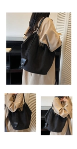 Detailed close-up of large black suede tote bag with drawstring tassels and smooth texture