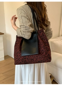 Detail of leopard print tote bag with black leather pocket and slim shoulder straps