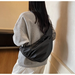 Close-up of black nylon dumpling bag showing waterproof texture and zipper detail