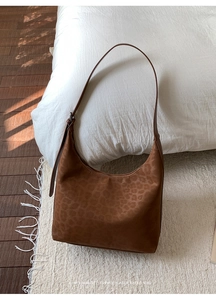 Detail of retro leopard print hobo bag showing matte suede texture and metal buckle strap