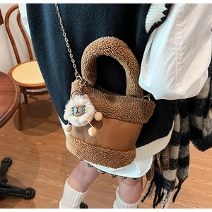 Détail du sac seau marron en polaire avec chaîne dorée et breloque alpaga douce