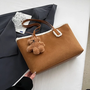 Dettaglio della borsa tote in pelle scamosciata marrone con bordo in pelliccia sintetica bianca