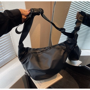 Detail of black nylon crescent bag featuring adjustable wide strap and plastic buckle