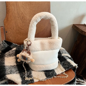 Détail du sac seau blanc en peluche teddy avec chaîne dorée et pendentif d'ours