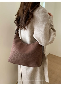 Detail view of suede leopard print tote bag with smooth metal zipper and sleek leather trim
