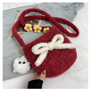 Détail du sac bandoulière en peluche rouge avec nœud blanc et sangle fleurie