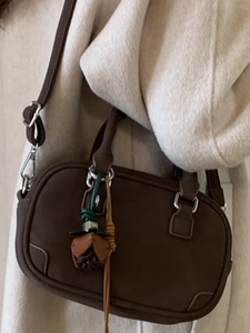 Retro deep brown leather handbag for women styled with a beige wool coat for fall