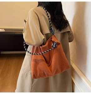 Detail of caramel corduroy tote bag showing textured fabric and plaid rope shoulder strap