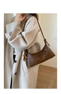 Detailansicht der braunen Leder-Hobotasche mit Vintage-Textur und bunter Perlenquaste