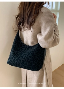 Detailed view of leopard print hobo bag with furry texture on beige cashmere coat