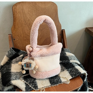Détail du sac seau en peluche rose avec breloque agneau et bandoulière dorée