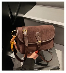 Détail du sac bandoulière en daim marron mat avec perles rétro et boucle dorée chic