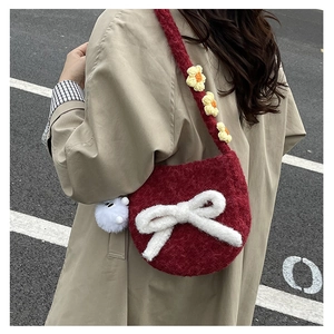 Détail du sac en peluche bordeaux avec nœud blanc et bandoulière fleurie en crochet doux