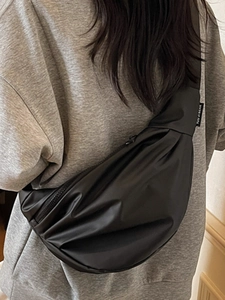 Minimalist black nylon crescent crossbody bag with adjustable wide shoulder strap for women