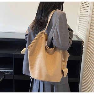 Detail of a large khaki faux suede tote bag with decorative pouch on shoulder strap