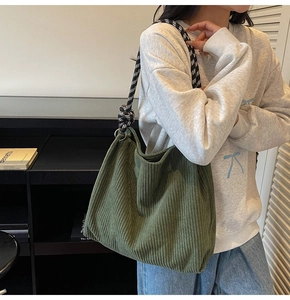 Detail of dark green corduroy tote bag with black and white checkered thick rope strap