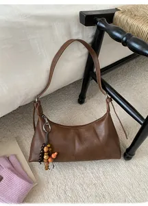 Detailansicht braune Vintage Achseltasche mit Holzperlen-Deko auf weißem Bettlaken