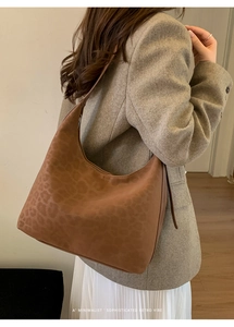 Detail showing retro brown leopard print tote bag worn on shoulder by model