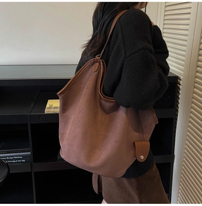 Detailed view of brown faux suede large tote bag with elegant leather edge piping